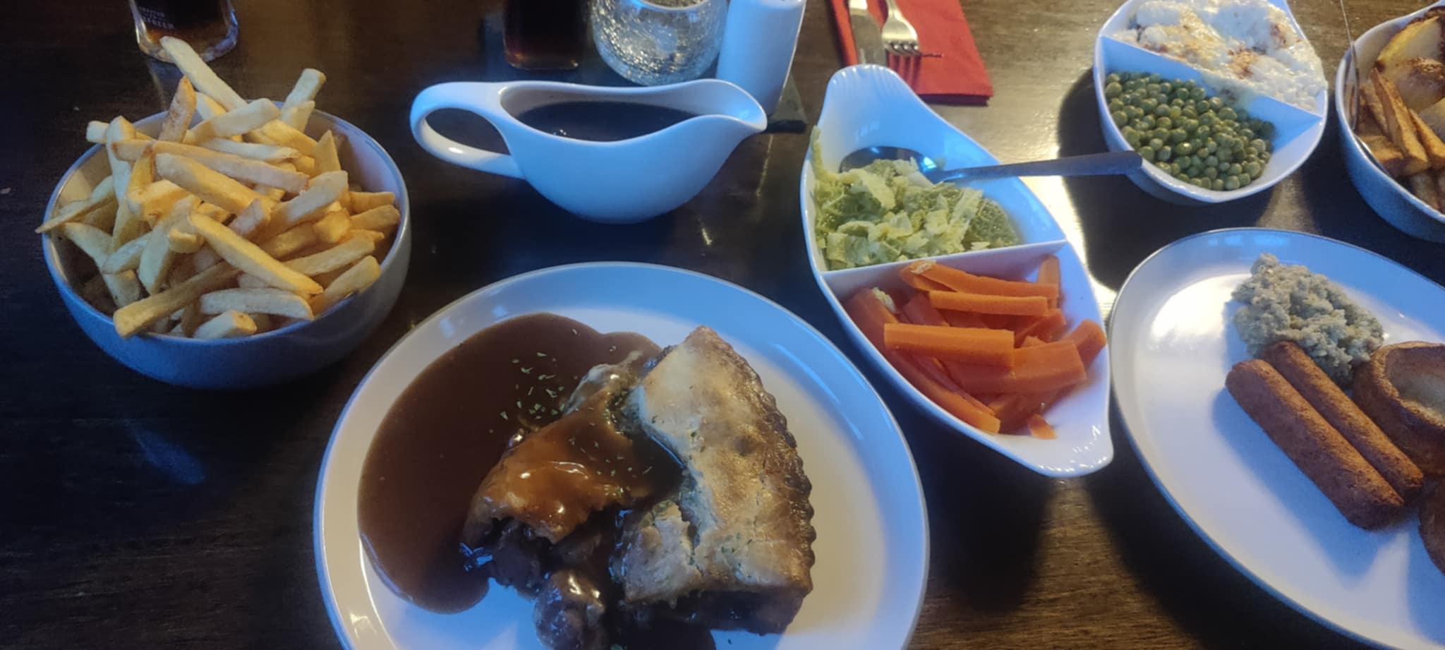 Generous pub food portions served at The Dukes Head in Hamstreet, with hearty dishes displayed on a rustic wooden table