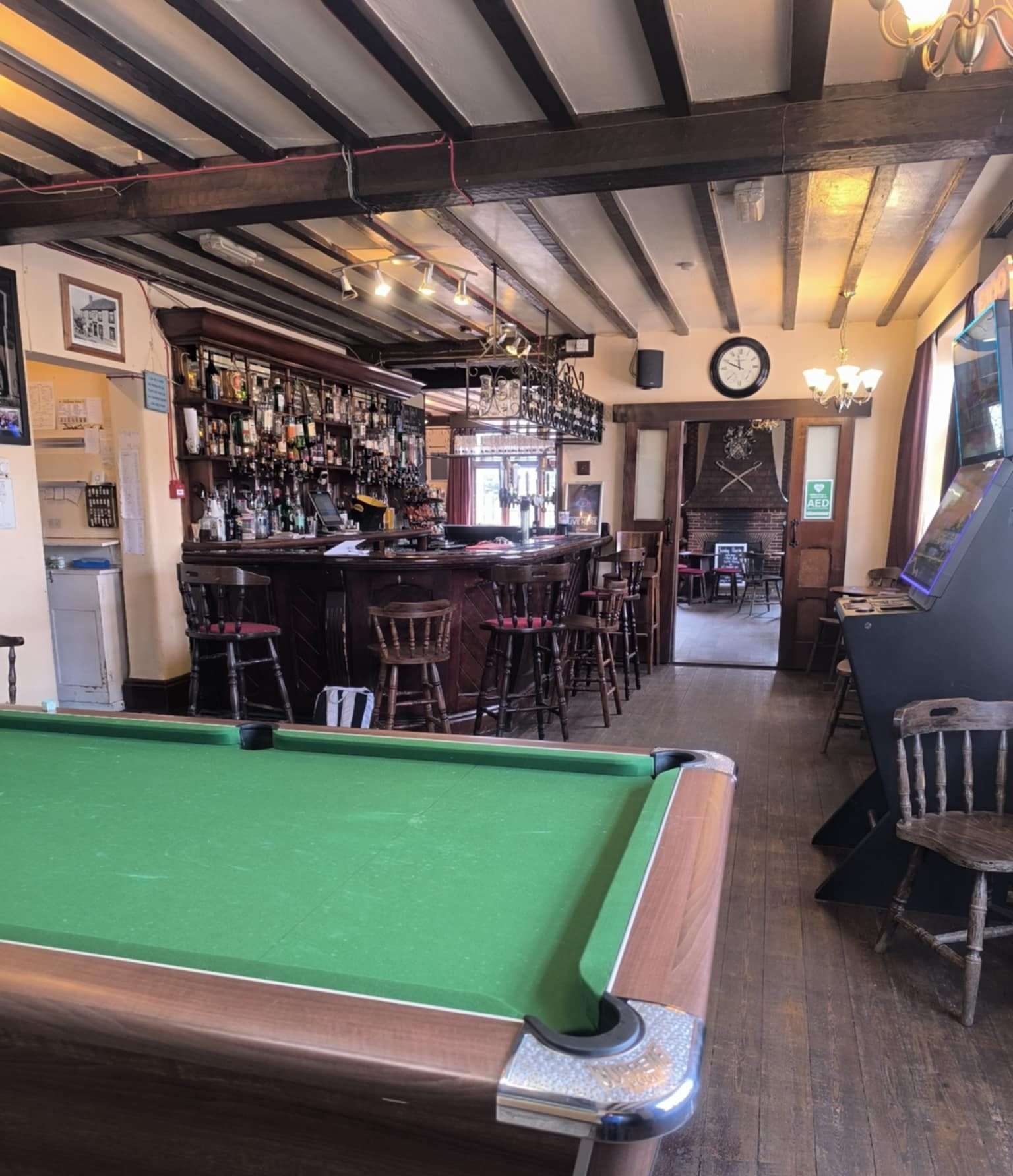 Interior of The Dukes Head pub in Hamstreet, Kent, featuring the bar, pool table, and cosy fireplace